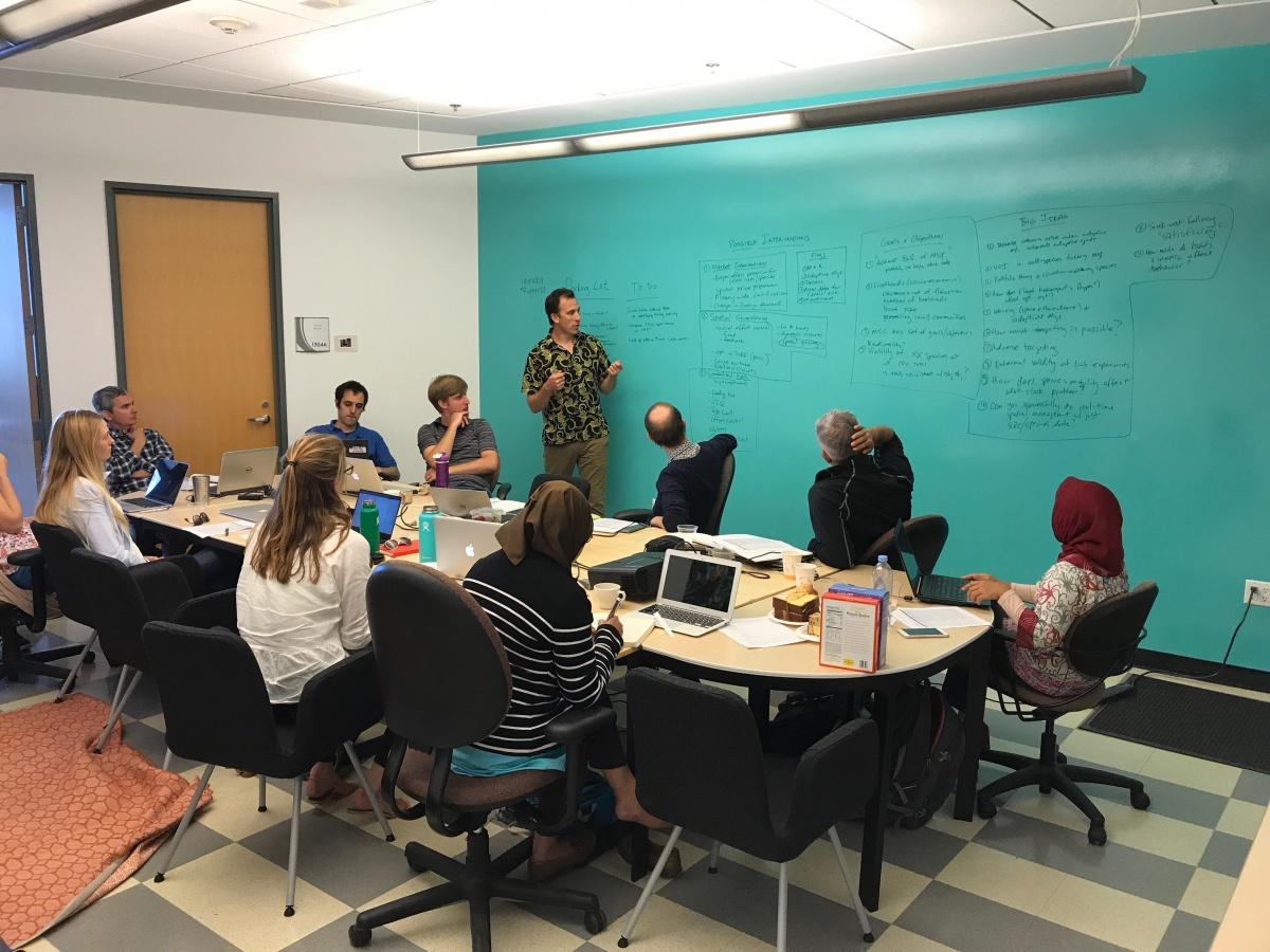 chris costello presenting in meeting room to emLab team